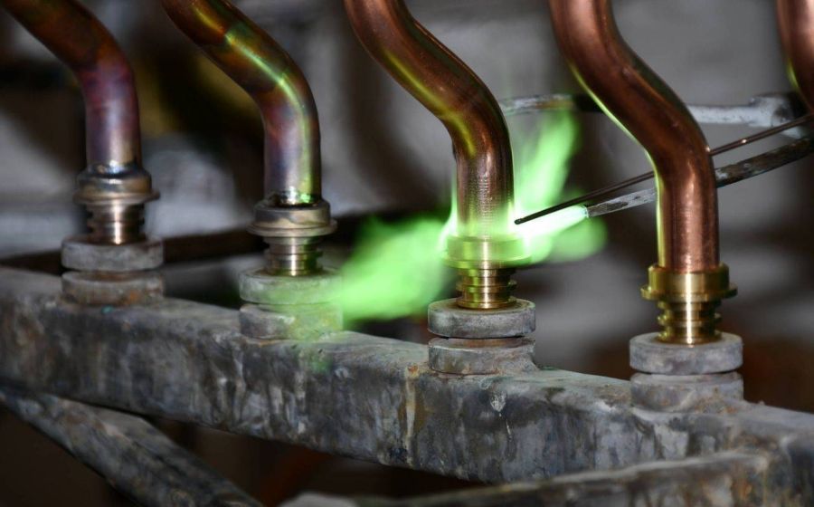 Brazing of copper pipes on brass fittings during HVAC manifold assembly.