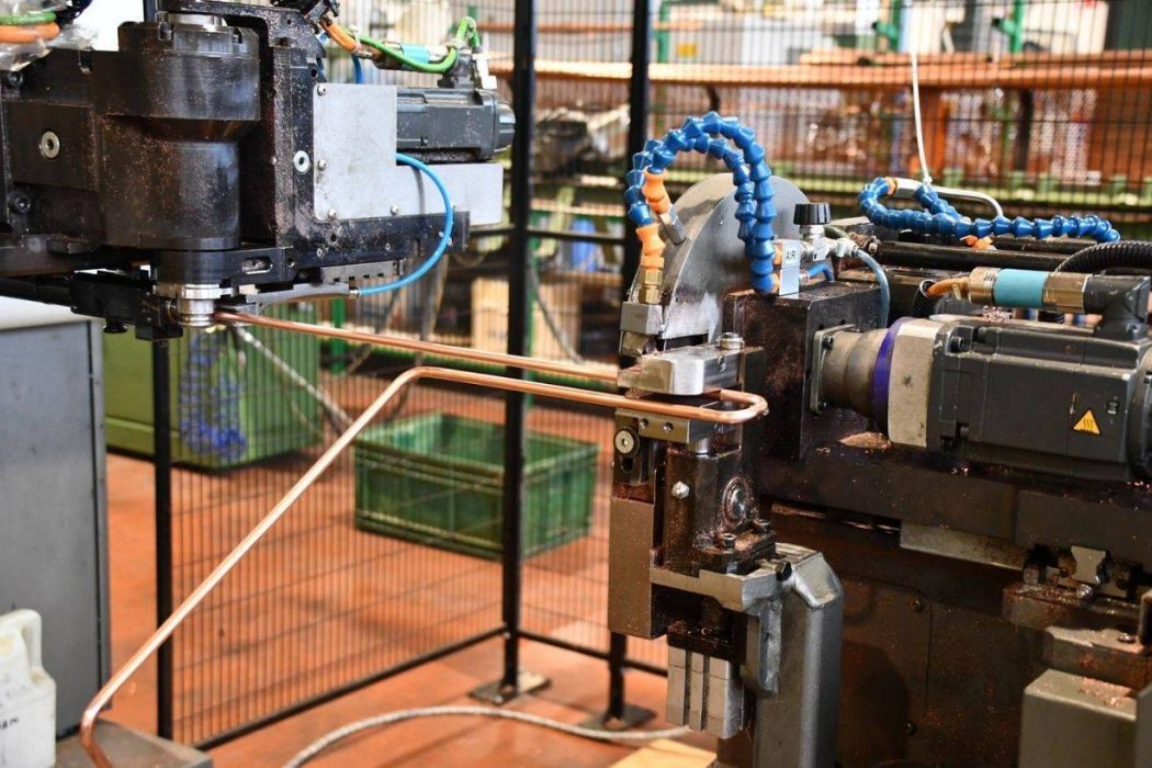 CNC tube bending machine forming copper tubes for HVAC and refrigeration components.