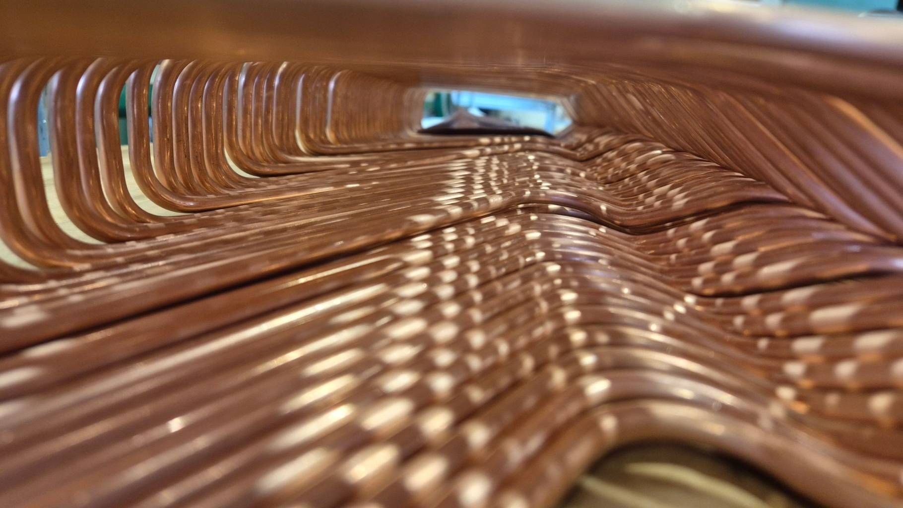 Close-up view of precision-bent copper tubes forming a coaxial heat exchanger for HVAC and refrigeration systems, manufactured by Macor S.R.L.