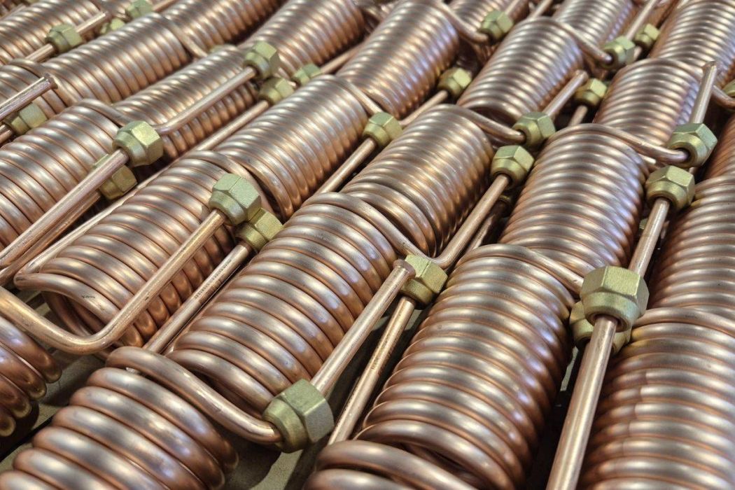 Copper coil heat exchanger assemblies with brazed fittings for HVAC and refrigeration systems.