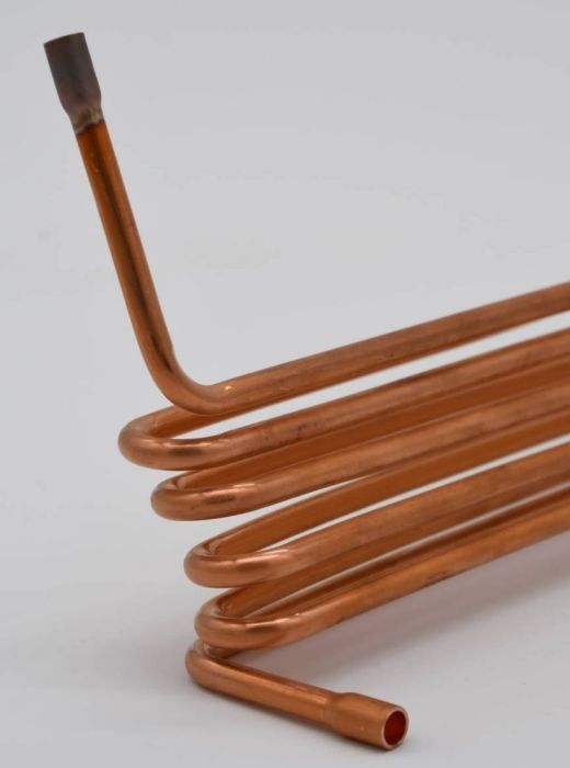 Custom-formed copper coil with multiple bends, manufactured for heat exchanger, HVAC, and refrigeration system applications.